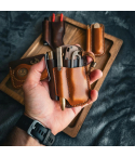 Leather EDC Pocket Organizer holding knife, flashlight, pen, and prybar in hand, full-grain vegetable-tanned leather design.
